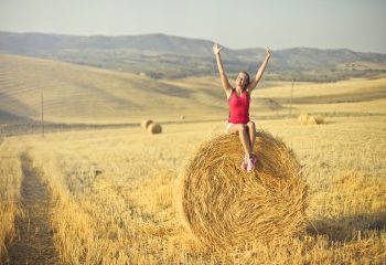 Canva - Woman Sitting on Hay Roll
